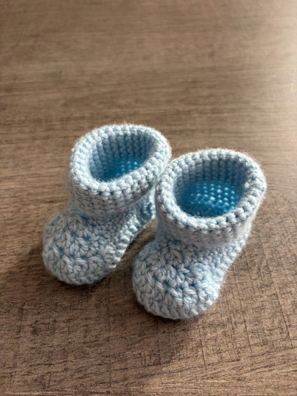 Détail de la paire de chaussons bleus crochetés à la main